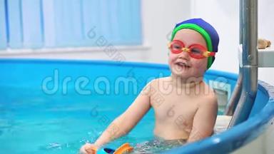 一个小男孩在游泳池里玩水缸。